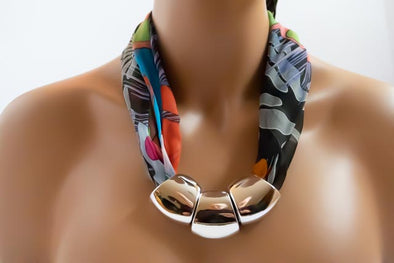 Silk plus Silver;   A combination of materials  for elegant designer made Inuit Art Necklaces. Inunoo's necklaces are made using selected silk chiffon scarf fabrics and three large acrylic beads with  Metallic Closures.  Twenty two to twenty four inches in length.