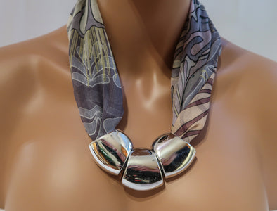 Silk plus Silver;   A combination of materials  for elegant designer made Inuit Art Necklaces. Inunoo's necklaces are made using selected silk chiffon scarf fabrics and three large acrylic beads with  Metallic Closures.  Twenty two to twenty four inches in length.